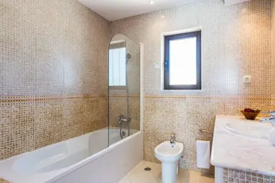 a bathroom with a tub and a sink and a toilet at Villa Bonita Gale in Galé