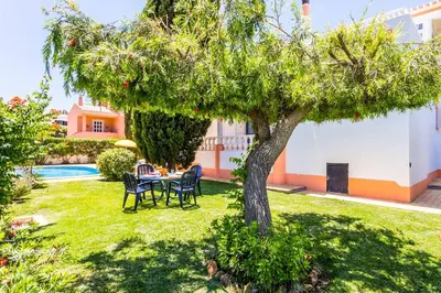 a table and chairs under a tree in a yard at Villa Bonita Gale in Galé