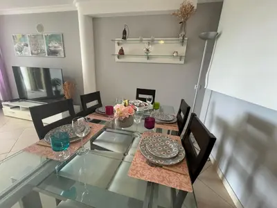 a glass dining room table with chairs and plates on it at Villa Martin in Albufeira