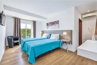 a hotel room with a blue bed and a window at Casa do Engenho in Galé