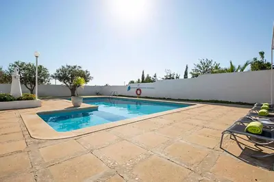 a swimming pool in a backyard with a white fence at Casa do Engenho in Galé