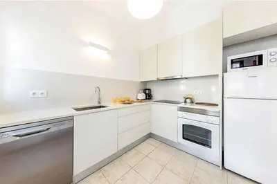 a white kitchen with white cabinets and appliances at Casa do Engenho in Galé