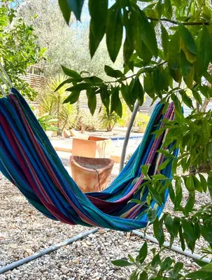 a hammock in a garden with a chair in it at The Quinta Retreat Algarve Available to Facilitators yoga & sound therapies, massage mindfulness in Almancil