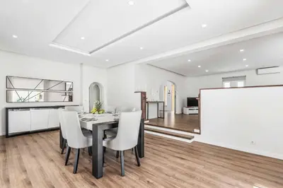 a dining room with a table and chairs and a whiteboard at Villa Corcovada in Albufeira