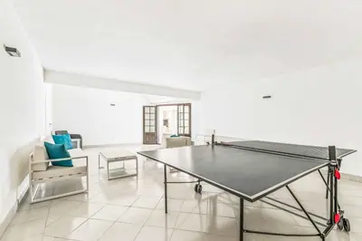 a ping pong table in a room with chairs at Villa Corcovada in Albufeira
