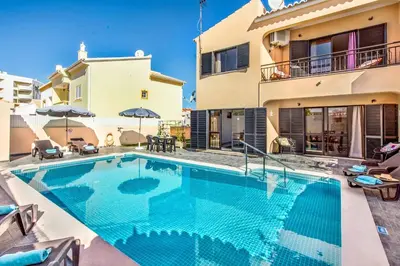 a swimming pool in front of a house at Villa Timoneiro in Galé