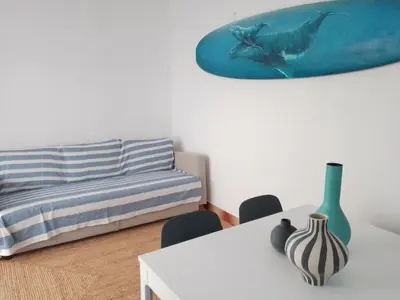 a living room with a couch and a table with a vase at BEACH HOUSE in Olhos de Água
