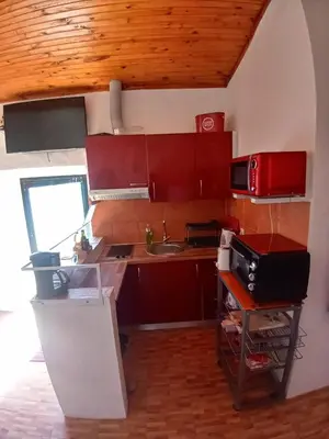 a small kitchen with red cabinets and a sink at Bela Vista House - Quinta amoreira in Benafim