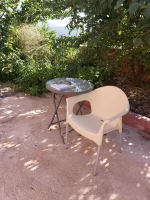 a table and a chair sitting next to a table at Bela Vista House - Quinta amoreira in Benafim