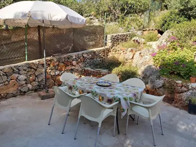 a table and chairs with an umbrella in a garden at Bela Vista House - Quinta amoreira in Benafim