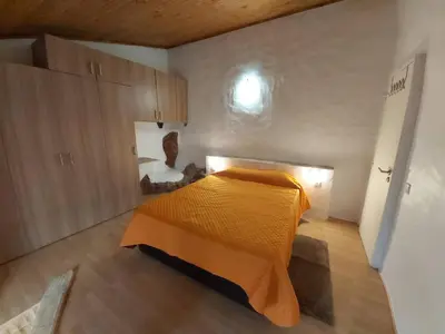 a bedroom with a bed with an orange blanket at Bela Vista House - Quinta amoreira in Benafim
