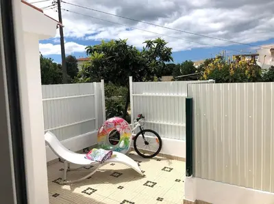 a bike parked next to a fence with a chair at Casa Vitoria - Olhos de Agua - Albufeira in Roja- Pé
