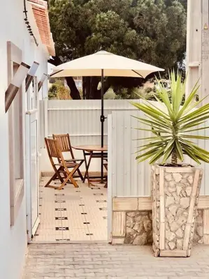 a patio with a table and an umbrella at Casa Vitoria - Olhos de Agua - Albufeira in Roja- Pé
