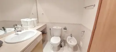 a white bathroom with a toilet and a sink at Apartment Lucia Albufeira in Olhos de Água