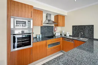 a kitchen with wooden cabinets and a stove top oven at Apartment Lucia Albufeira in Olhos de Água