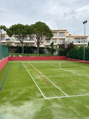 a tennis court in front of a building at Apartment Lucia Albufeira in Olhos de Água