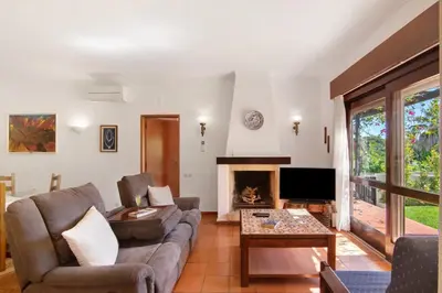 a living room with a couch and a fireplace at Casa Mila by Sunnyway in Olhos de Água