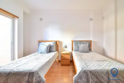 a bedroom with two beds with pink sheets and a window at Vila Alfarrobeira by MTPhomes in Albufeira