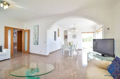 a living room with a glass table and a pool at Vila Alfarrobeira by MTPhomes in Albufeira