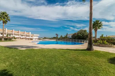 a swimming pool in a yard next to a building at Apartamento albufeira cerro da águia in Albufeira