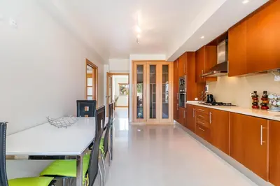 a kitchen with wooden cabinets and a dining table at Apartamento albufeira cerro da águia in Albufeira