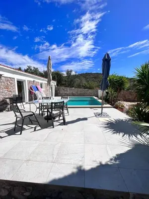 a patio with a table and chairs and a pool at Typical quiet Algarve cottage in Faro
