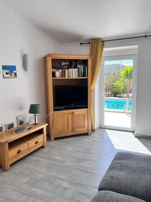 a living room with a tv and a large window at Typical quiet Algarve cottage in Faro