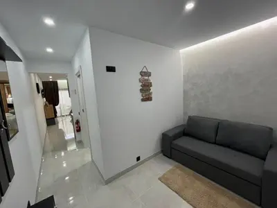 a living room with a couch against a white wall at Comfy Home in Albufeira