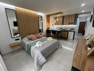 a bedroom with a large bed and a kitchen at Comfy Home in Albufeira