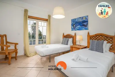 a room with two beds and a chair in it at #201 Families Only - Quinta da Flor in Albufeira