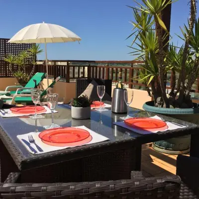 a table with plates and wine glasses on a patio at Apartment Rosmaninho-Hosted by Sweetstay in Quarteira