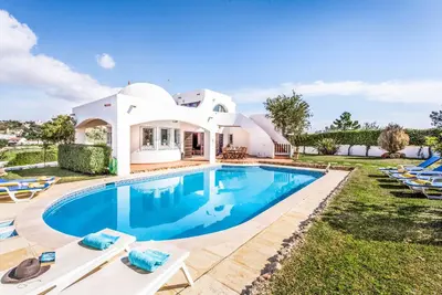 a villa with a swimming pool in front of a house at Villa Gira in Albufeira