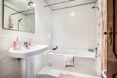 a white bathroom with a sink and a tub at Villa Gira in Albufeira