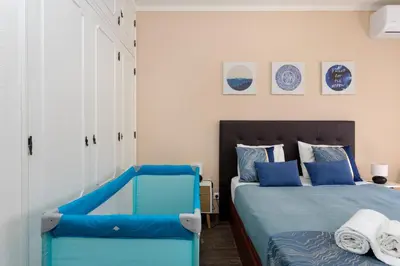 a bedroom with a blue bed and two blue chairs at Algarvian Experience - Sun, Beach and Pool in Albufeira