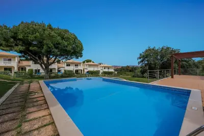 a large blue swimming pool in front of a house at Meadow View Retreat in Albufeira