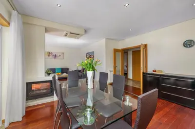 a dining room with a glass table and chairs and a fireplace at Meadow View Retreat in Albufeira