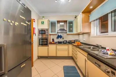 a kitchen with a sink and a refrigerator at Avenue Apartment Vilamoura in Quarteira