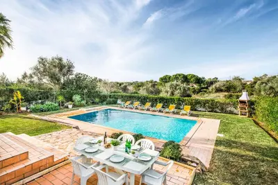 a pool with a table and chairs in a yard at Villa Barrancos in Guia