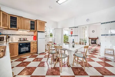 a kitchen with a checkered floor and a table and chairs at Villa Barrancos in Guia