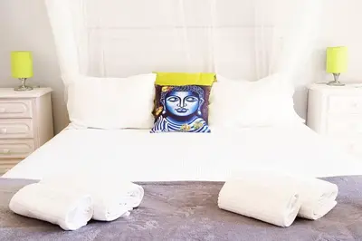 a white bed with two pillows and a blue face pillow at Villa Mirasol - Relaxed Private Villa in Albufeira