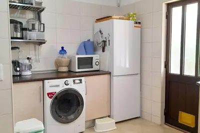 a kitchen with a washing machine and a refrigerator at Villa Mirasol - Relaxed Private Villa in Albufeira