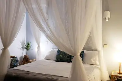 a bedroom with a white canopy bed with white curtains at Villa Mirasol - Relaxed Private Villa in Albufeira