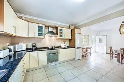 a kitchen with white appliances and a dining room at Villa Godinho in Albufeira