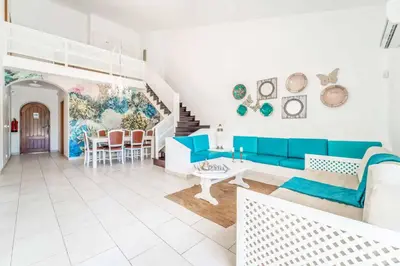 a living room with a blue couch and a table at Villa Catarino in Albufeira