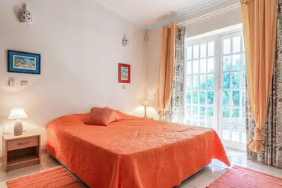 a bedroom with a bed and a large window at Villa Gabie in Albufeira