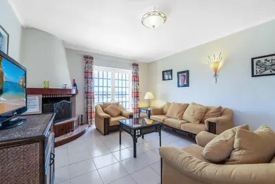 a living room with two couches and a tv at Villa Gabie in Albufeira