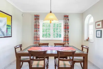 a dining room with a table and chairs and a window at Villa Gabie in Albufeira
