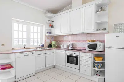 a kitchen with white cabinets and a white refrigerator at Villa Gabie in Albufeira