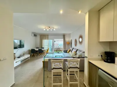 a kitchen with a table and a stainless steel refrigerator at Why Knot Beach, Marina Nearby in Quarteira