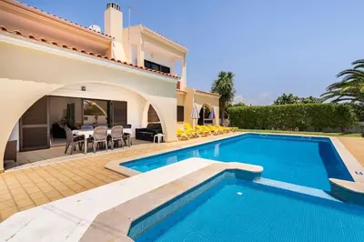 a villa with a swimming pool in front of a house at Villa Palmeiras - Serene Private Villa in Albufeira